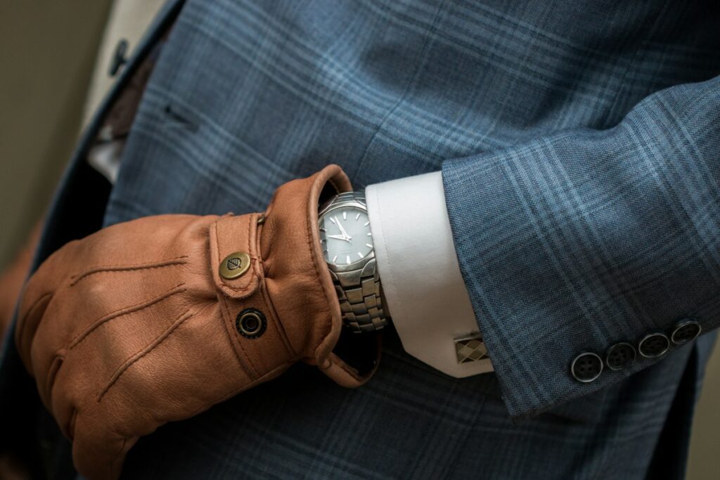 Gants homme en cuir camel portés avec une veste de costume
